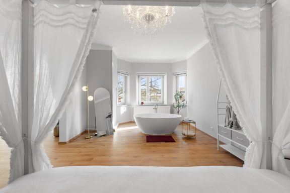 Ferienwohnung Miesbach - Liebelei - Schlafzimmer mit freistehender Badewanne Heller, eleganter Raum mit freistehender Badewanne und großen Fenstern.