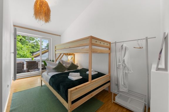 Ferienwohnung Miesbach – Flussperle: Helle Wohnung mit Etagenbett und Terrasse Helle, minimalistische Wohnung mit Etagenbett und Zugang zur Terrasse.